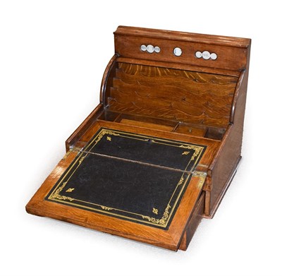 Lot 314 - A Late Victorian Oak Travelling Writing Desk, the shaped hinged top over perpetual calendar...