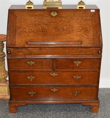 Lot 425 - An Early 18th Century Oak Bureau, the fall enclosing a sliding well, pigeon holes and small...