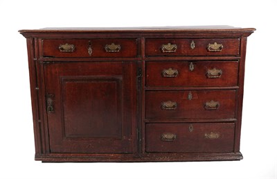 Lot 437 - An 18th Century Enclosed Oak Dresser Base, the three plank top above an arrangement of drawers...