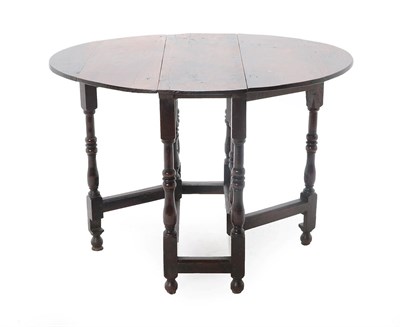 Lot 446 - An Oak Gateleg Dining Table, circa 1700, with two rounded drop leaves to form an oval, on...