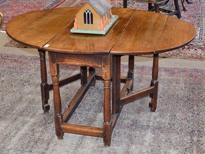 Lot 457 - An Early 18th Century Oak Gateleg Table, with two drop leaves to form an oval, on baluster legs...