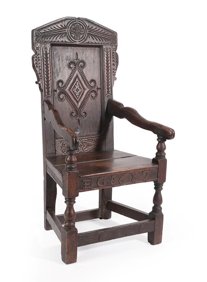 Lot 458 - A Joined Oak Wainscot Armchair, dated 1687 EG, the carved top rail above a scroll and lozenge...