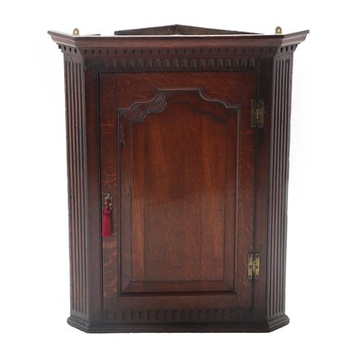 Lot 462 - A George III Oak Hanging Corner Cupboard, 3rd quarter 18th century, the dentil and fluted...