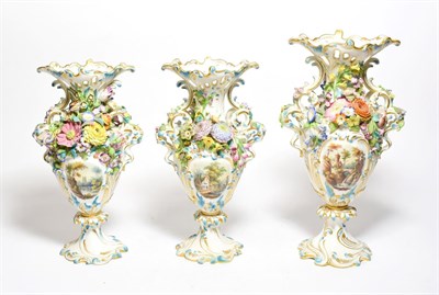 Lot 130 - A Continental porcelain vase garnitures, each painted with vignettes of pastoral scenes,...