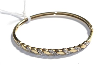 Lot 295 - A 9 carat gold diamond hinged bangle