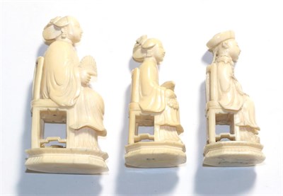 Lot 303 - Three Chinese ivory figures seated on chairs