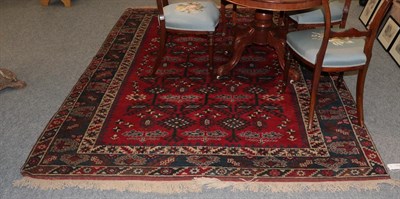 Lot 1114 - A Yagibedir carpet, the claret angular latch hook lattice field enclosed by indigo borders,...