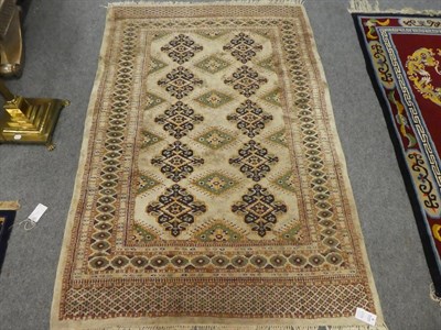 Lot 1115 - A Pakistan ''Bukhara'' rug, the ivory field of medallions enclosed by multiple borders, 187cm...