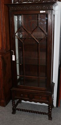 Lot 1149 - A carved oak glazed display cabinet