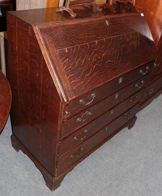 Lot 1161 - A George III oak bureau with fitted interior and four long drawers