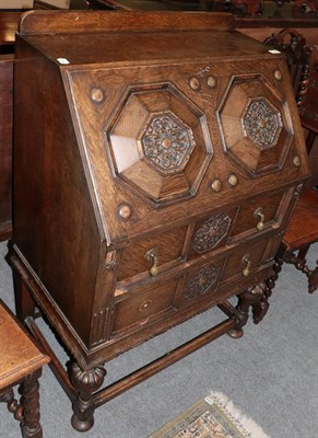 Lot 1229 - An early 20th century carved oak bureau with moulded panel front