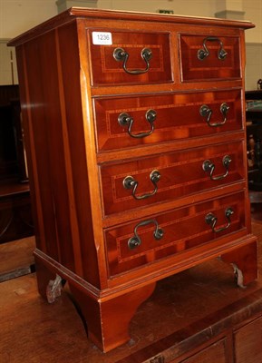 Lot 1236 - A reproduction yew wood five drawer chest of drawers and a reproduction yew wood hall table