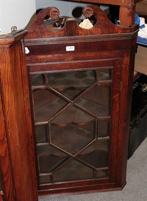 Lot 1253 - A George III oak astragal hanging corner cupboard