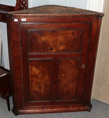 Lot 1255 - A fruit wood corner cupboard with figured elm panels