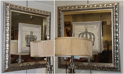 Lot 1310 - A pair of modern square form mirrors with silvered and carved frames
