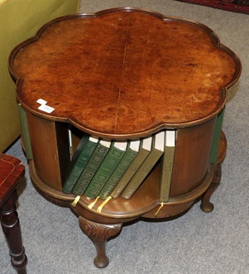 Lot 1357 - A 1930s burr walnut revolving bookcase table bearing labels from Simpsons, Silver Street, Halifax