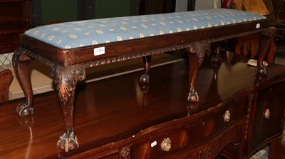 Lot 1364 - An early 20th century carved mahogany double foot stool on claw and ball feet, 125cm wide