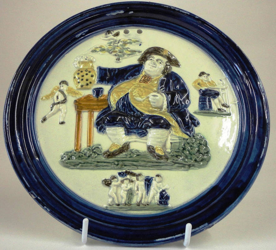 Lot 82 - A Pratt Type Pottery Circular Wall Plaque, circa 1800, moulded and picked out in typical underglaze