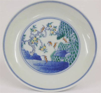 Lot 167 - A Chinese Porcelain Doucai Saucer, painted with bats amongst fruiting branches and waves, the...