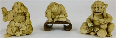 Lot 201 - Three Japanese Carved Elephant Ivory Netsukes, circa 1900, one as Daikoku seated on a rice bale...