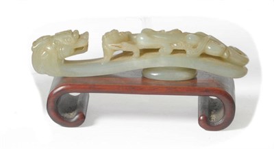 Lot 233 - A Chinese Carved Pale Celadon Jade-Type Belt Hook, Qing Dynasty, carved with an openwork qilong...