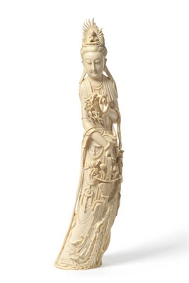 Lot 246 - A Chinese One Piece Carved Elephant Tusk Standing Figure of Guanyin, circa 1930, the serene goddess