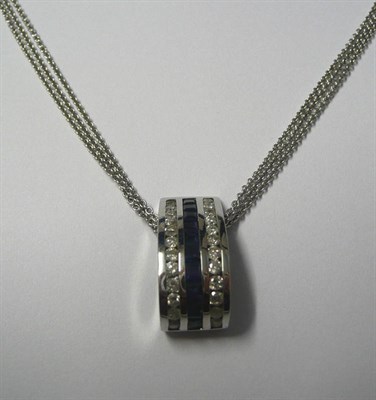 Lot 493 - A Sapphire and Diamond Pendant on Chain, the curved pendant with a central row of step cut...