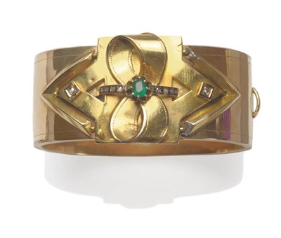 Lot 502 - A Russian Bangle, as a broad cuff with a bow detail overlay, this set with an emerald and rose...