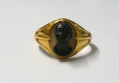 Lot 507 - A Blackamoor Ring, the portrait carved in sardonyx to a decorative mount on a yellow plain polished