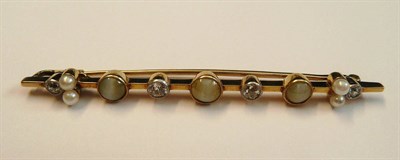 Lot 526 - A Bar Brooch, set with three cat's-eye chrysoberyls, and four old cut diamonds in millegrain...