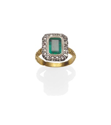 Lot 528 - An Emerald and Diamond Cluster Ring, the step cut emerald within a border of rose cut diamonds...