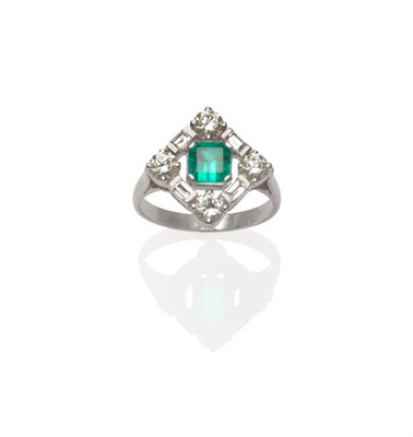 Lot 531 - An 18 Carat White Gold Emerald and Diamond Cluster Ring, the emerald-cut emerald within a border of