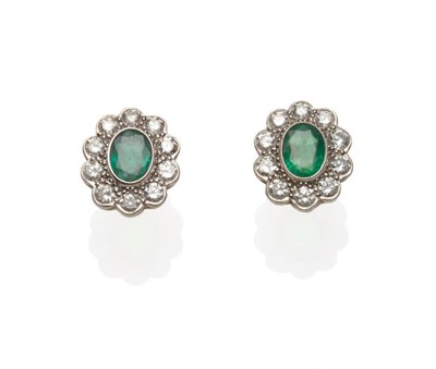 Lot 532 - A Pair of Emerald and Diamond Cluster Earrings, the oval cut emeralds within a border of round...