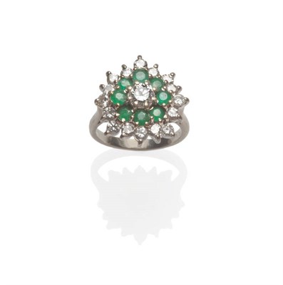 Lot 533 - An Diamond and Emerald Cluster Ring, a round brilliant cut diamond within a border of emeralds,...