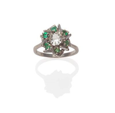 Lot 534 - A Diamond and Emerald Cluster Ring, an old cut diamond within a star effect border of emeralds...