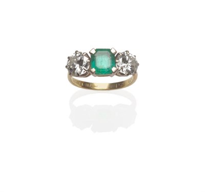 Lot 536 - An 18 Carat Gold Emerald and Diamond Three Stone Ring, the emerald-cut emerald flanked by a...