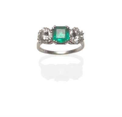 Lot 537 - An Emerald and Diamond Three Stone Ring, a step cut emerald with a round brilliant cut diamond...