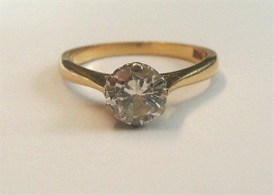 Lot 543 - A Diamond Solitaire Ring, the round brilliant cut diamond in a white claw setting, to a yellow...