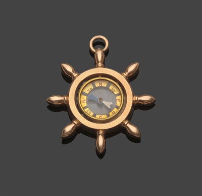 Lot 549 - A Compass Pendant, the compass enclosed within a ship's wheel motif with a pendant loop,...