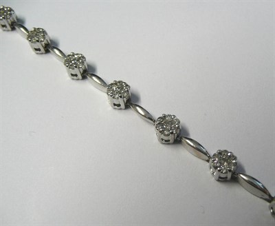 Lot 555 - A Diamond Bracelet, round brilliant cut diamond clusters in white claw settings, spaced by polished