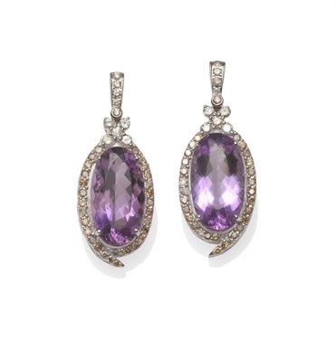 Lot 560 - A Pair of Amethyst and Diamond Earrings, an oval cut amethyst within a border of round...