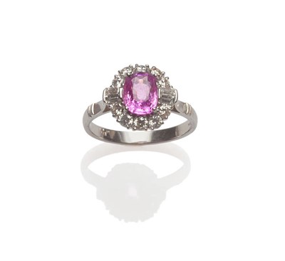 Lot 561 - An 18 Carat White Gold Pink Sapphire and Diamond Cluster Ring, an oval mixed cut pink sapphire...