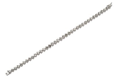 Lot 566 - A Diamond Line Bracelet, round brilliant cut diamonds in white three claw settings, total...