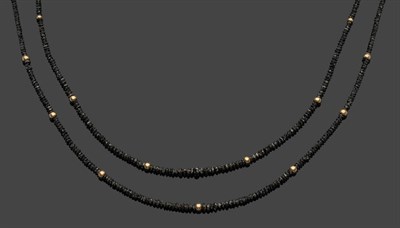 Lot 575 - A Two Row Black Diamond Necklace, the graduated faceted diamonds spaced at intervals by a gold...