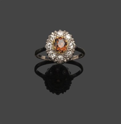 Lot 577 - A Diamond Cluster Ring, an oval cut cinnamon coloured diamond within a border of white round...