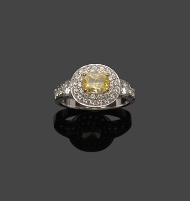 Lot 579 - A Diamond Ring, an oval cut yellow diamond within a pavé set white diamond surround, in yellow and