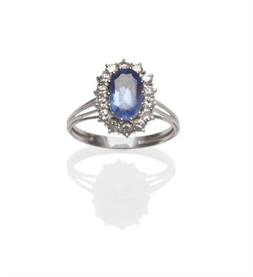 Lot 629 - A Sapphire and Diamond Cluster Ring, the oval cut sapphire within a border of round brilliant...