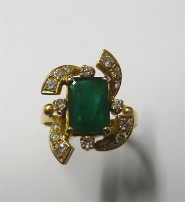 Lot 633 - An Emerald and Diamond Cluster Ring, a step cut emerald within a scrolling frame set with diamonds