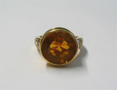 Lot 634 - An 18 Carat Gold Citrine and Diamond Ring, a round brilliant cut citrine bezel set, with a pair...