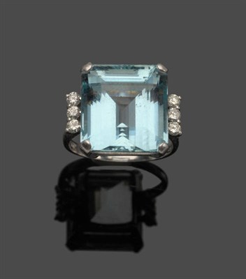 Lot 646 - An 18 Carat White Gold Aquamarine and Diamond Ring, the step cut aquamarine flanked by three...